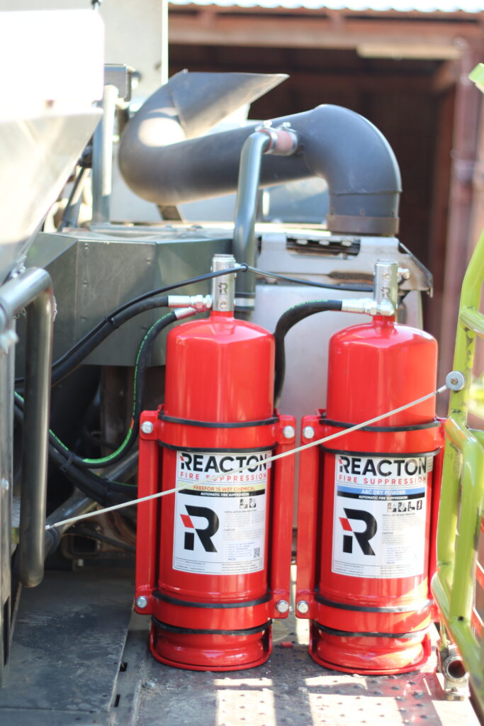 Two Reacton fire extinguishing system cylinders are installed in the engine compartment of the CLASS Lexion 660 combine harvester, connected to the detection and spray lines.