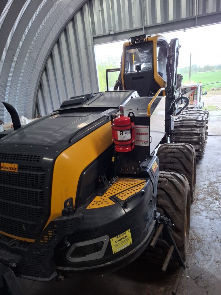 PONSSE Scorpion harvester in Unitruck workshop during installation of REACTON automatic fire suppression system on forestry machinery.